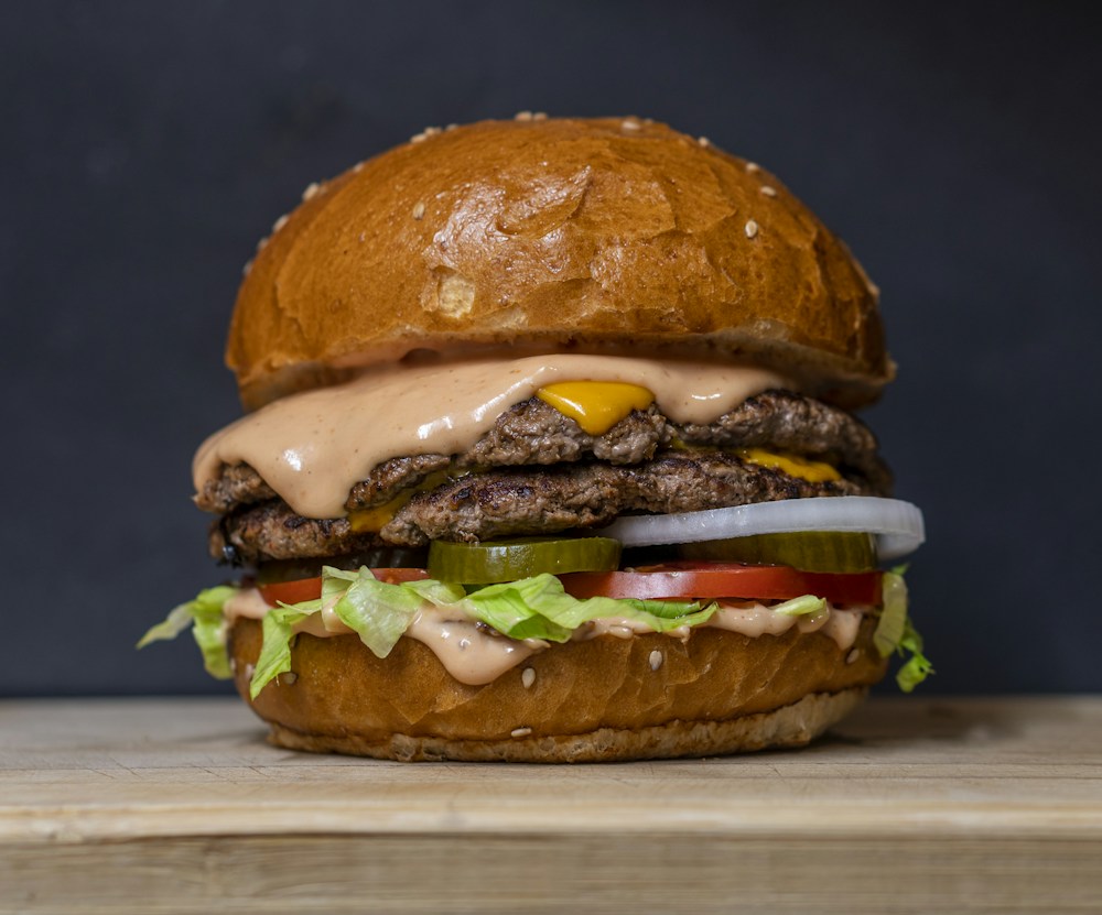 Hamburguesa con pan de ajonjolí, carne, queso y vegetales frescos